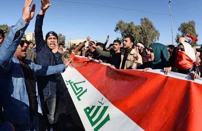 مواجهات بين المحتجين وقوى الأمن في بغداد والنجف.. وإحراق مقر لـ”حزب الله العراق” –  شاهد فيديو